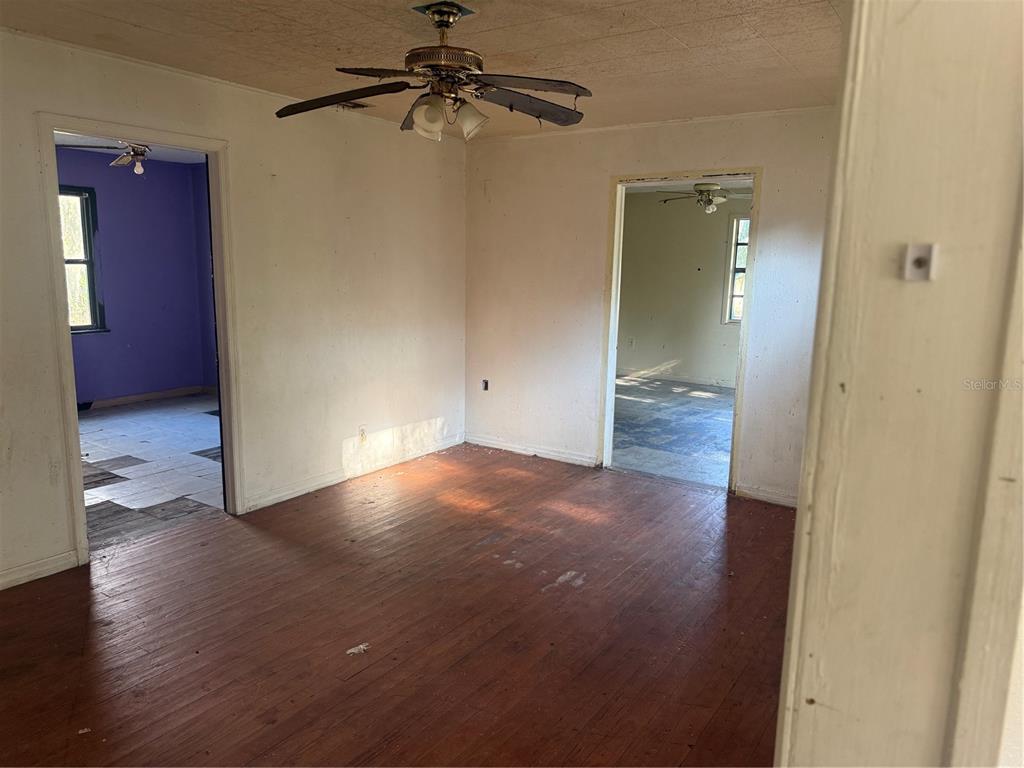 An interior view of a room with hardwood floors, a ceiling fan, and two doorways — 830 BLOXHAM AVENUE, PUNTA GORDA, FL