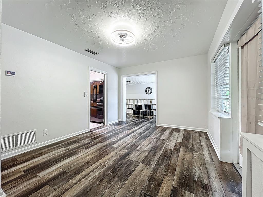 A room with wood-look flooring, white walls, a textured ceiling, and a ceiling fan light — 2542 S PALMETTO AVENUE, SANFORD, FL