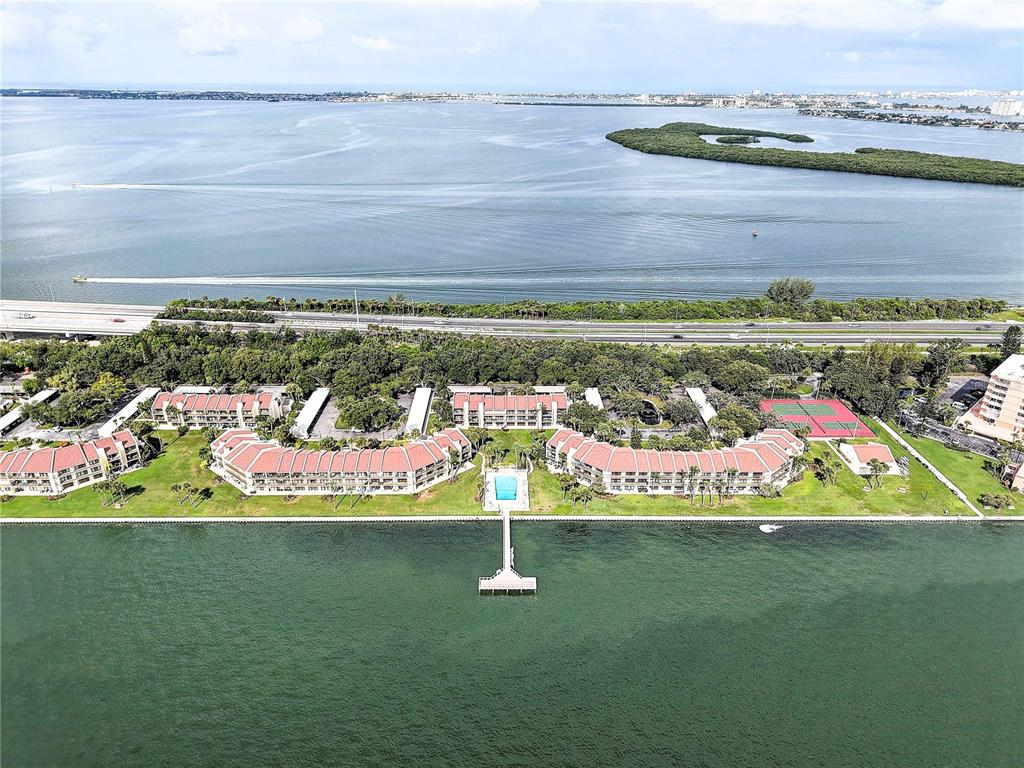 Aerial view of a waterfront residential complex with a pier and tennis courts — 7510 SUNSHINE SKYWAY LANE S UNIT T13, ST PETERSBURG, FL