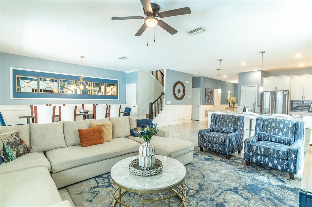 A living room features a large sectional sofa, two patterned armchairs, and a marble coffee table — 1532 MAIDSTONE COURT, DAVENPORT, FL