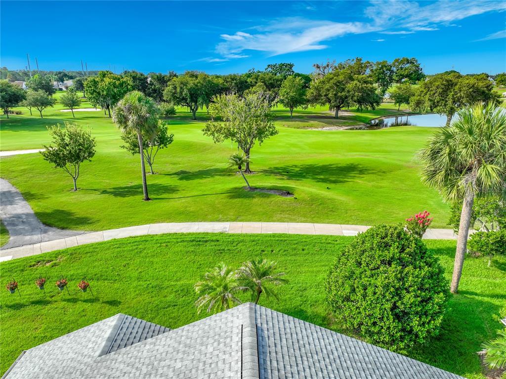 An elevated view of a grassy golf course with trees and a small pond — 6328 GREENGATE DRIVE, ORLANDO, FL