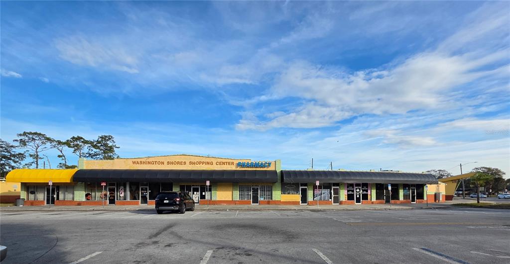 A single-story commercial strip mall with a yellow facade and black awnings under blue skies — 3625 COLUMBIA STREET, ORLANDO, FL