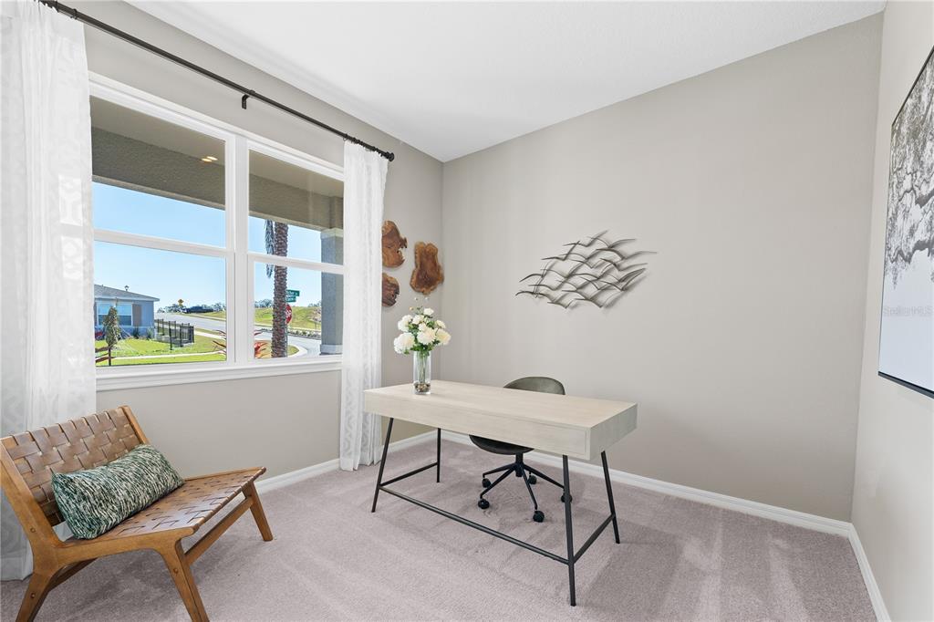 A home office with a desk, chair, accent chair, and a window overlooking a street — 23615 GRINDSTONE WAY, SORRENTO, FL