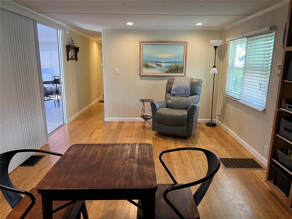 A living area features light wood flooring, a gray recliner, and a small dining table — 2601 GULF DRIVE N UNIT S2, BRADENTON BEACH, FL