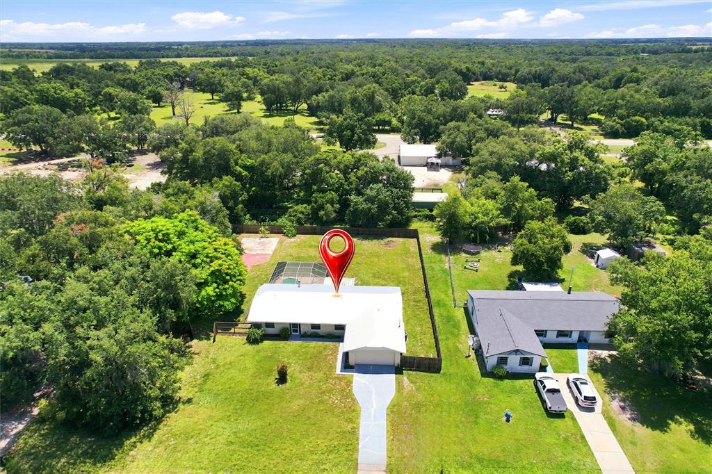 An aerial view shows a white house with a pool and a large grassy yard — 2848 SE NORMAN AVENUE, ARCADIA, FL