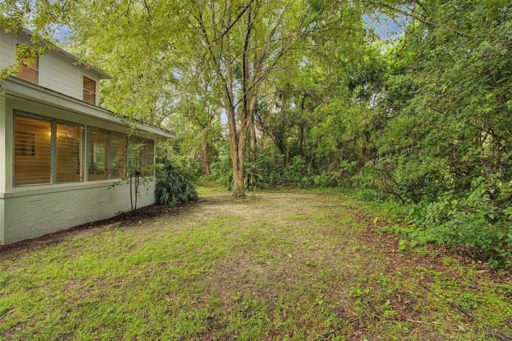 An aerial view shows a house with a hip roof surrounded by dense trees — 2721 SW 3RD PLACE, GAINESVILLE, FL