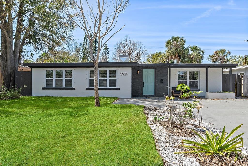 A single-story house with a white exterior, dark trim, and a light blue front door — 3926 HELENA STREET NE, ST PETERSBURG, FL