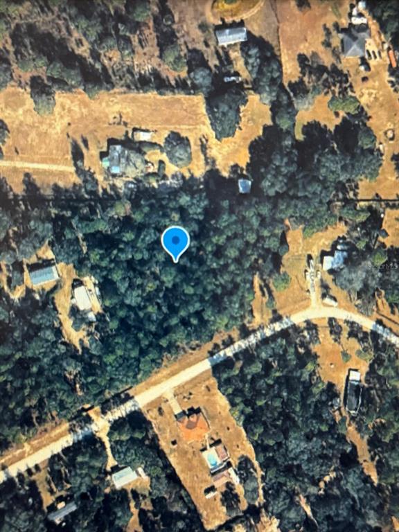 This is an aerial map view of a wooded residential lot marked with a blue pin — 00 SW 47TH PLACE ROAD LOT 6, OCALA, FL