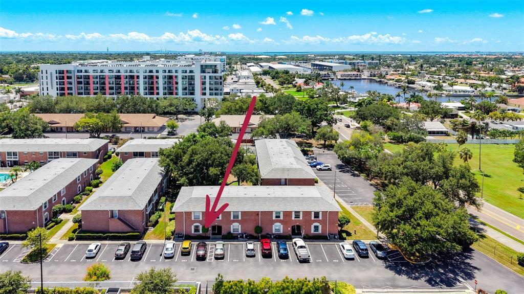 An aerial view shows a multi-story brick apartment building with a parking lot in front — 3574 41ST AVENUE S UNIT 149, ST PETERSBURG, FL