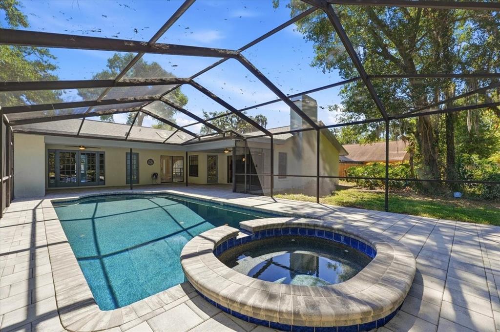 A screened-in patio features a rectangular swimming pool with an attached spa and paver decking — 2800 HAMMOCK DRIVE, PLANT CITY, FL