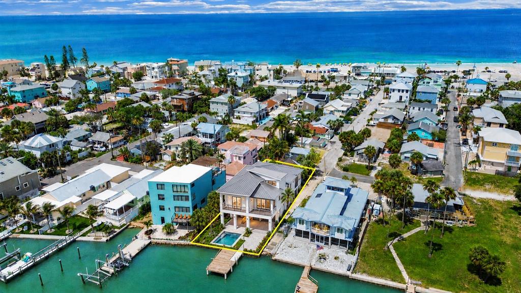An aerial view of a waterfront property featuring a wooden dock and a small house — 201 90TH AVENUE, TREASURE ISLAND, FL