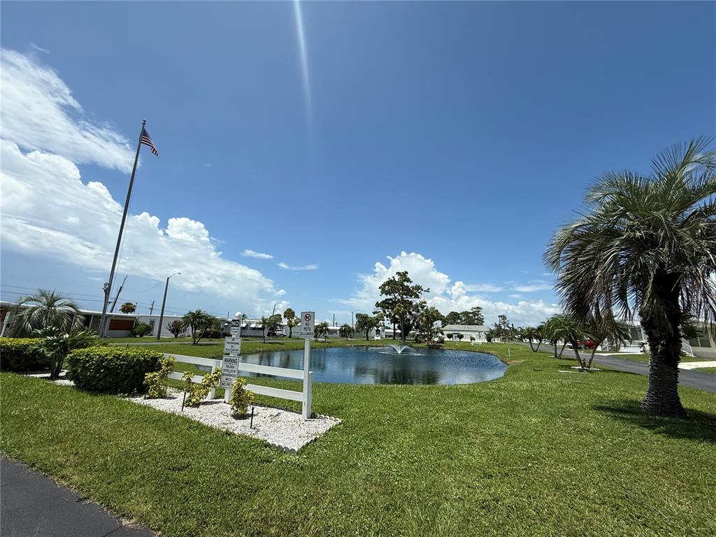A pond with a fountain sits in the center of a residential mobile home park — 231 INNER DRIVE E, VENICE, FL