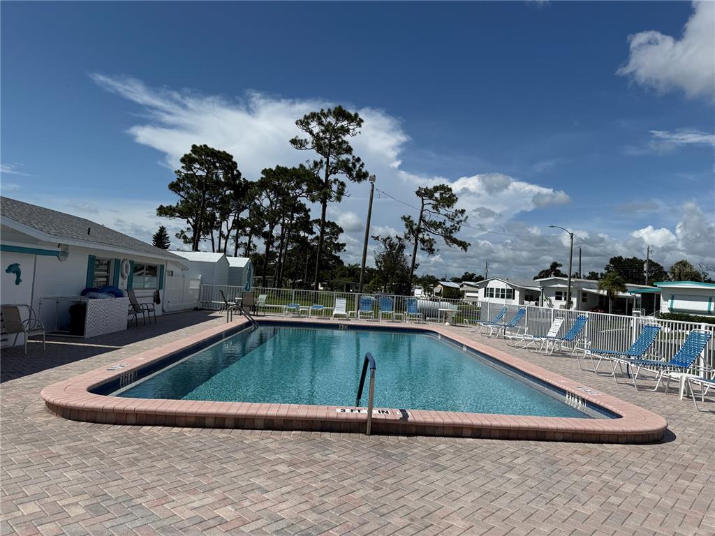 A large community hall features multiple tables, chairs, a stage, and a drop ceiling — 231 INNER DRIVE E, VENICE, FL