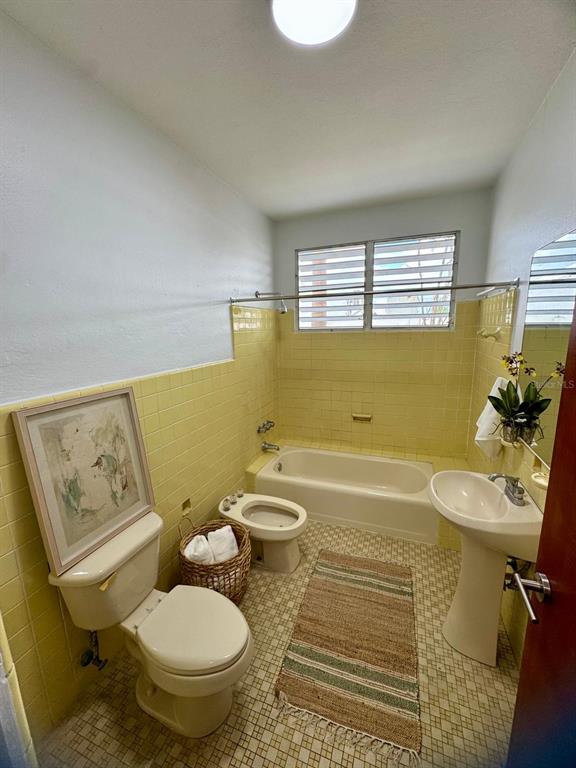 A bathroom features yellow wall tiles, a pedestal sink, a toilet, a bidet, and a tub — F-6 CALLE GENOVA UNIT F-6, GUAYNABO, PR
