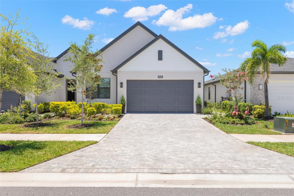 A single-story house with a gray garage door, white siding, and a paved driveway — 5828 WINDBREAK COURT, APOLLO BEACH, FL