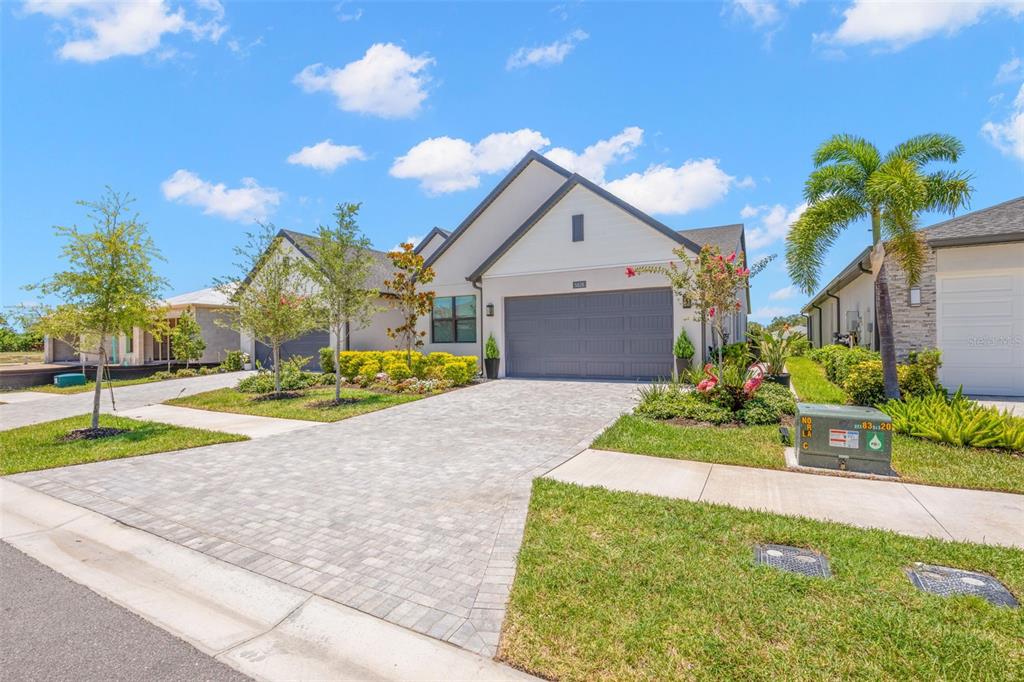A single-story suburban house with a gray garage, paved driveway, and a palm tree — 5828 WINDBREAK COURT, APOLLO BEACH, FL