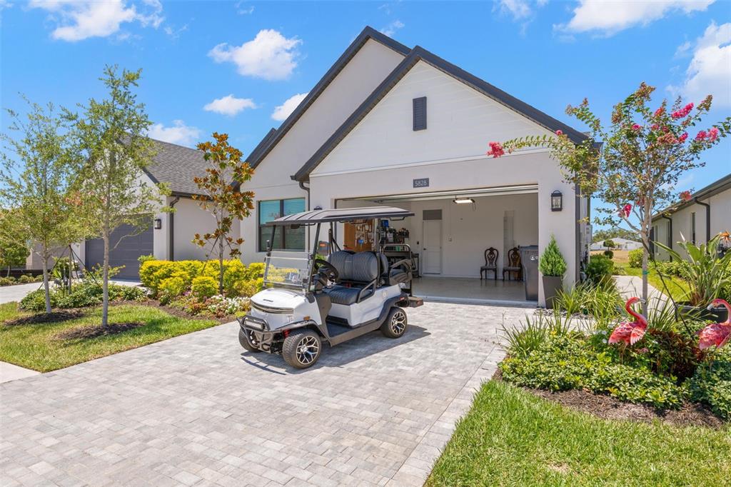 A white golf cart is parked on a paver driveway in front of a house — 5828 WINDBREAK COURT, APOLLO BEACH, FL