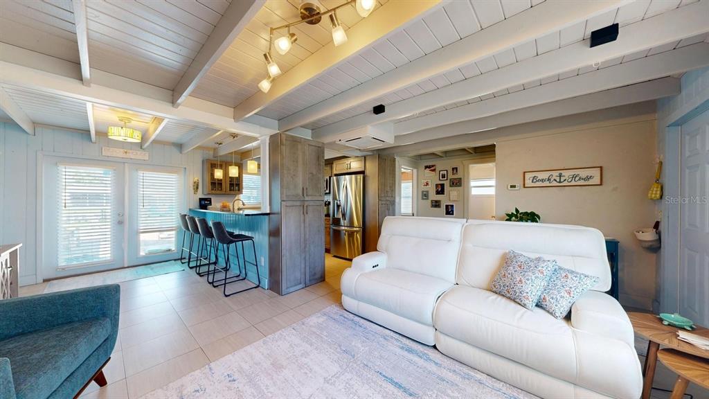 A living room features light blue paneled walls, a white vaulted ceiling, and coastal decor — 119 N PALMETTO AVENUE, FLAGLER BEACH, FL