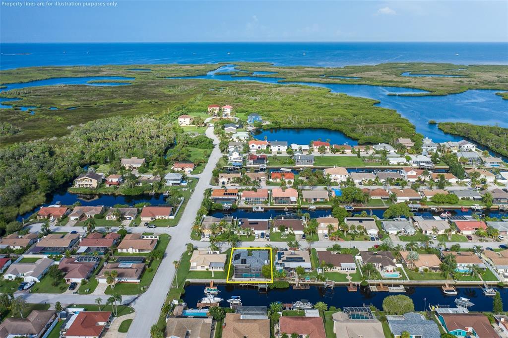 An aerial view shows a residential neighborhood with houses along canals leading to a bay — 9816 SAN MATEO WAY, PORT RICHEY, FL