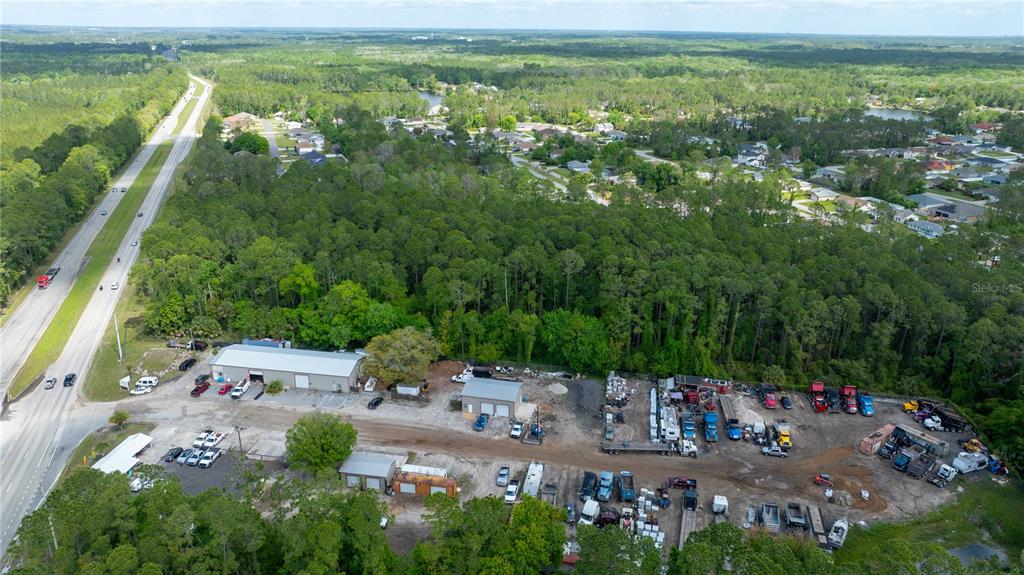 An aerial view shows a commercial property with several buildings and vehicles near a highway — 2270 US HIGHWAY 1, BUNNELL, FL