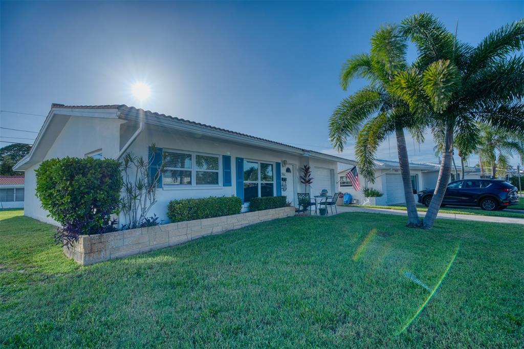 A single-story white house with blue shutters and a palm tree in the front yard — 9610 45TH STREET N, PINELLAS PARK, FL