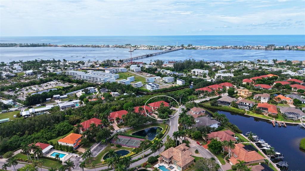 An aerial view shows a residential neighborhood with a circled house near a waterway — 12402 HARBOUR LANDINGS DRIVE, CORTEZ, FL