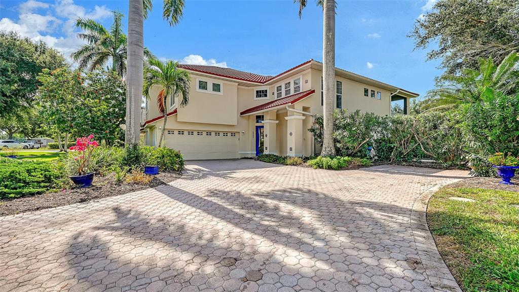 A two-story house with a paved driveway, a multi-car garage, and palm trees — 12402 HARBOUR LANDINGS DRIVE, CORTEZ, FL
