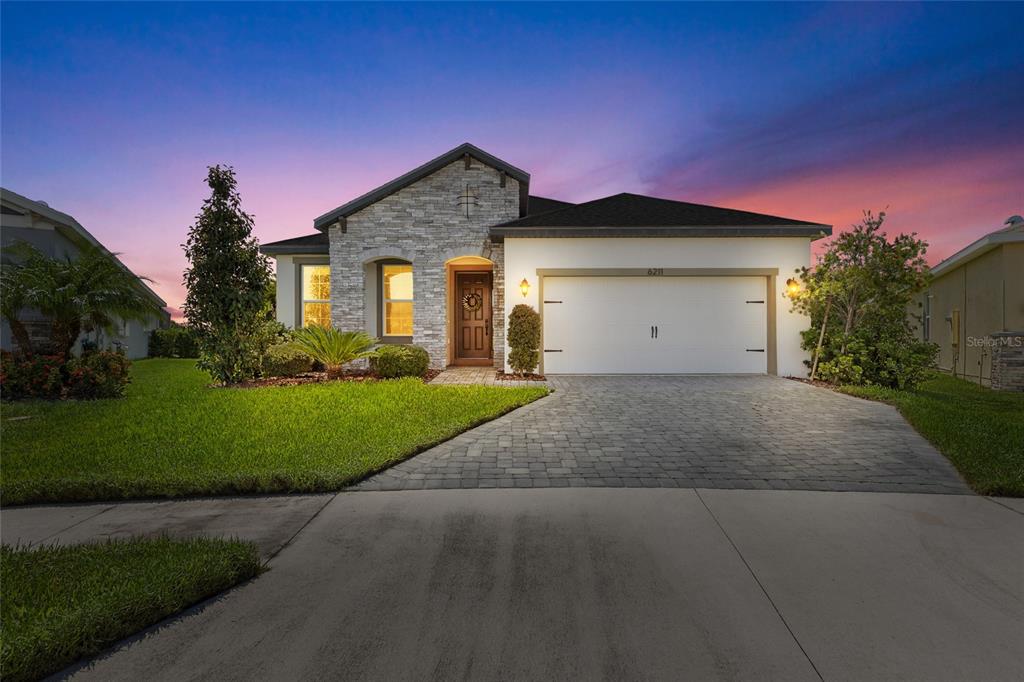 A single-story house with a stone facade, a two-car garage, and a paved driveway — 6211 SEA AIR DRIVE, APOLLO BEACH, FL