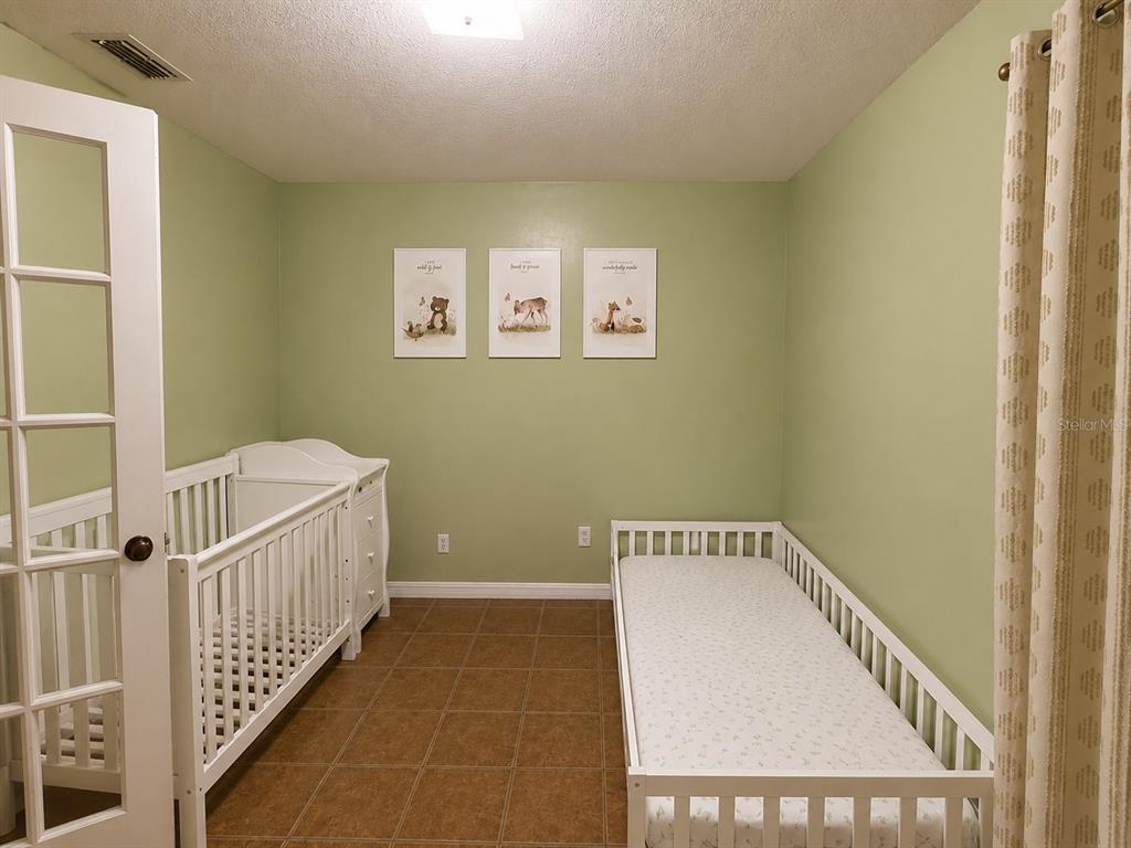 A small bathroom with tan tile flooring, white walls, and a white toilet — 2113 N NORMANDY BOULEVARD, DELTONA, FL