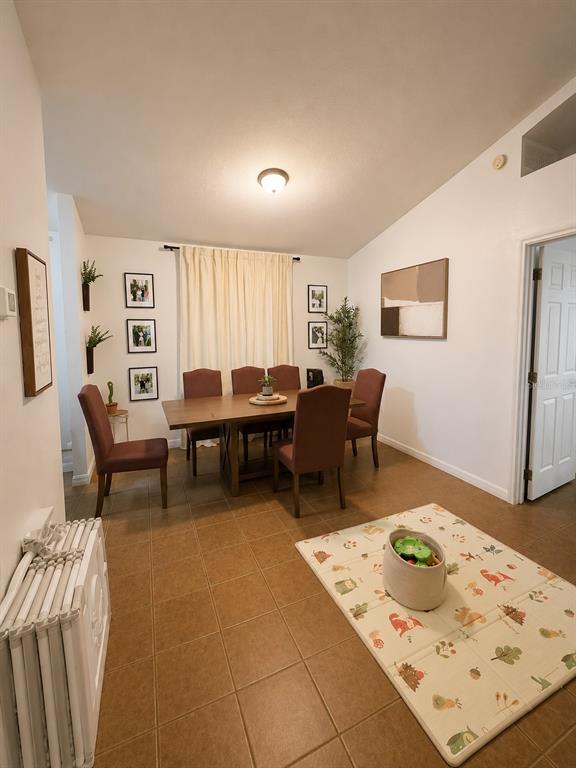 A living room features tile flooring, a white sofa, a television, and children's play equipment — 2113 N NORMANDY BOULEVARD, DELTONA, FL