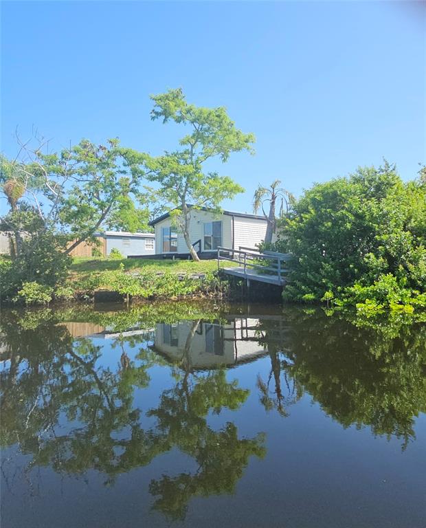 A single-story house with a deck and a small dock overlooking a canal — 13147 CABIN COURT, HUDSON, FL