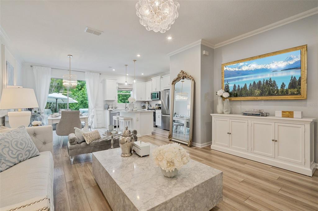 A bright living room features a marble coffee table, a large mirror, and white cabinetry — 896 SPRING PALMS LOOP, ORLANDO, FL