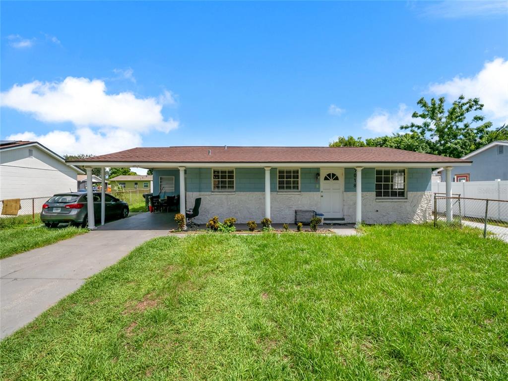 A single-story house with a blue and white exterior, a carport, and a front lawn — 7018 GLENVIEW DRIVE, TAMPA, FL