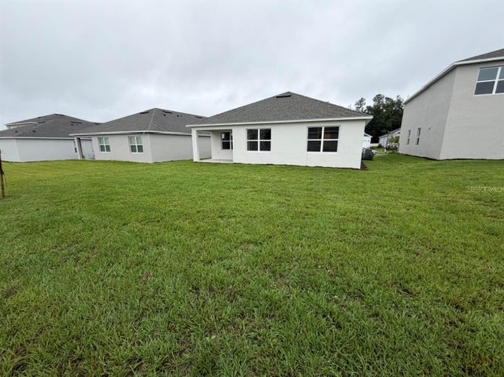 A kitchen with light gray cabinets, white countertops, a central island, and light wood flooring — 4922 MARSHELDER STREET, APOPKA, FL