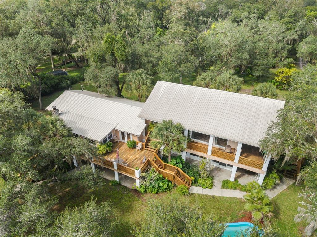 An aerial view of a two-story house with a metal roof and a wooden deck — 2033 SE HIGHWAY 317, OLD TOWN, FL