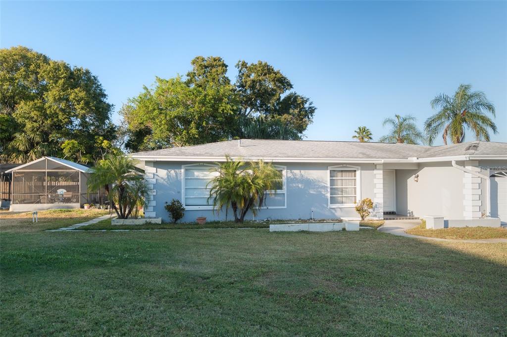 A single-story light blue house with a white front door and a screened-in patio area — 4710 SHALE PLACE, TAMPA, FL