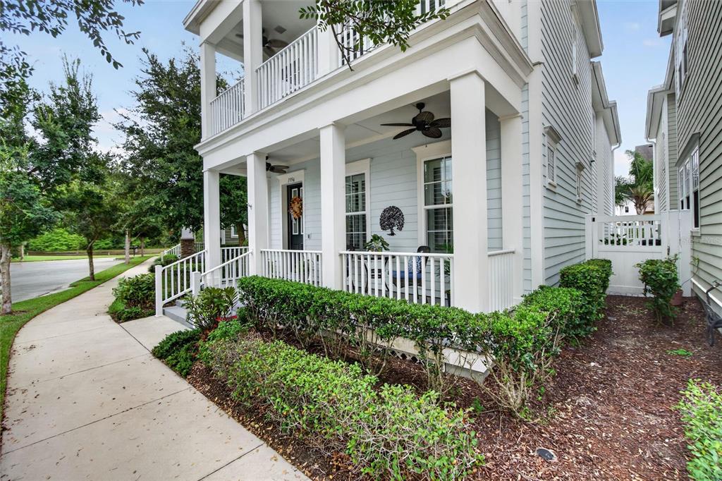A light blue two-story house features a covered front porch with white columns and railings — 1356 CAP ROCK DRIVE, CELEBRATION, FL