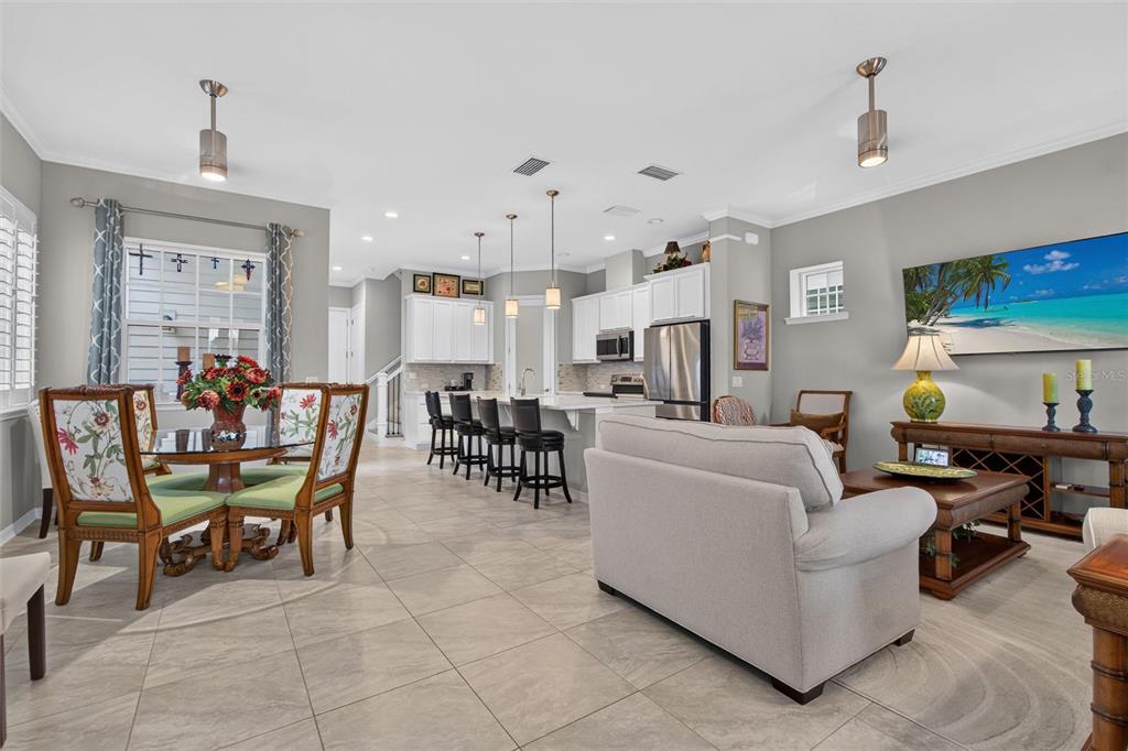 An open-concept kitchen and living area with tile floors, white cabinetry, and a dining set — 1356 CAP ROCK DRIVE, CELEBRATION, FL