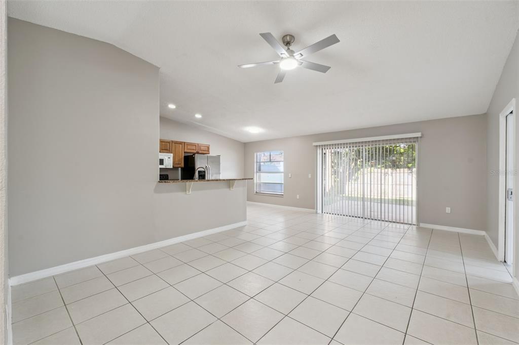 A kitchen with wood cabinets and a breakfast bar overlooks a tiled dining area — 3122 LORRY LANE, ORLANDO, FL