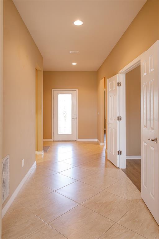 A tiled entryway features tan walls, recessed lighting, and white doors leading to other rooms — 672 CORDOBA DRIVE, DAVENPORT, FL