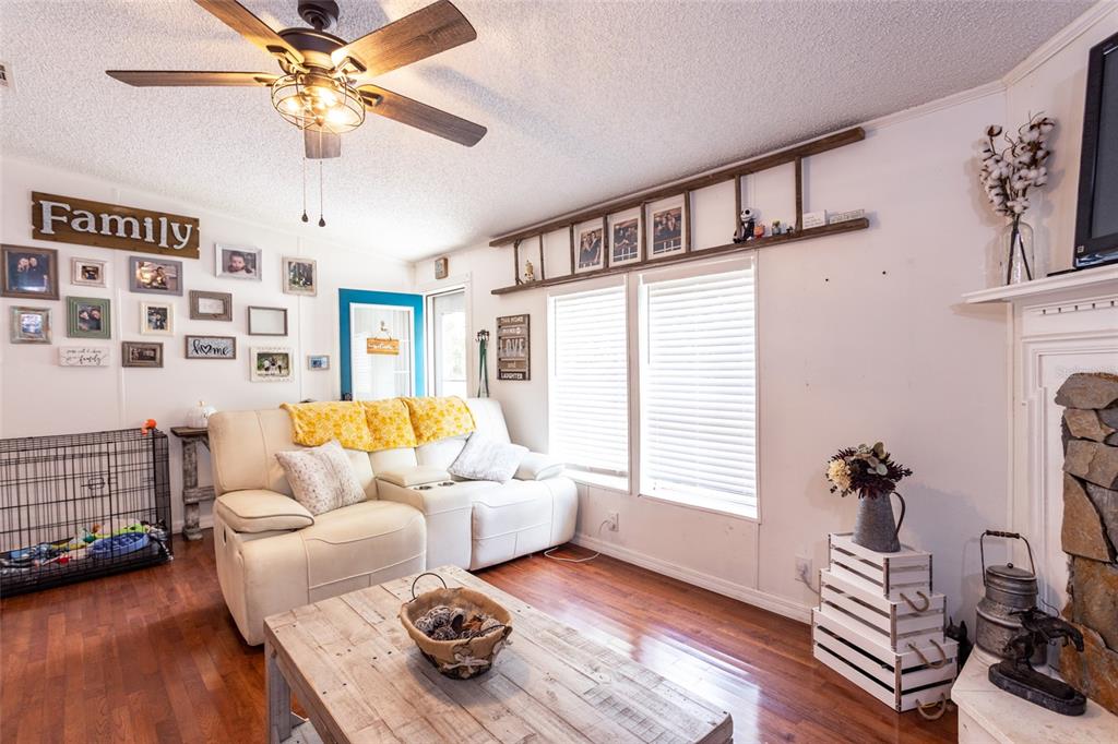 A living room features a white sofa, a wooden coffee table, and a decorative wall ladder — 1013 FOREST PARK STREET, BUNNELL, FL