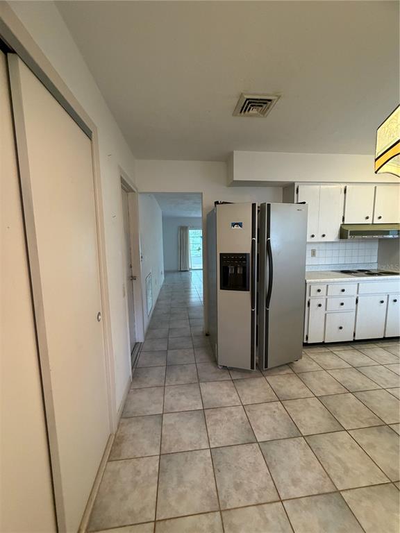 A kitchen features white cabinets, a double sink, a built-in oven, and tiled flooring — 29768 67TH STREET N, CLEARWATER, FL