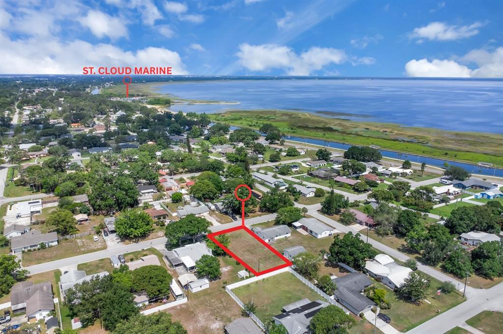 An aerial view shows a vacant rectangular lot outlined in red near a large lake — DELAWARE AVENUE, ST CLOUD, FL