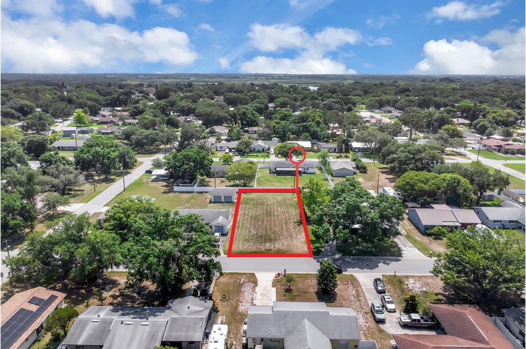 An aerial view shows a vacant rectangular residential lot outlined in red on a suburban street — DELAWARE AVENUE, ST CLOUD, FL