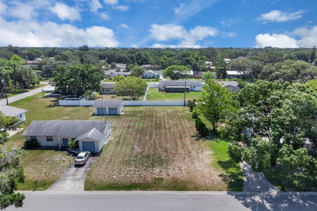 An aerial view shows a single-story house with a detached garage and a large vacant lot — DELAWARE AVENUE, ST CLOUD, FL