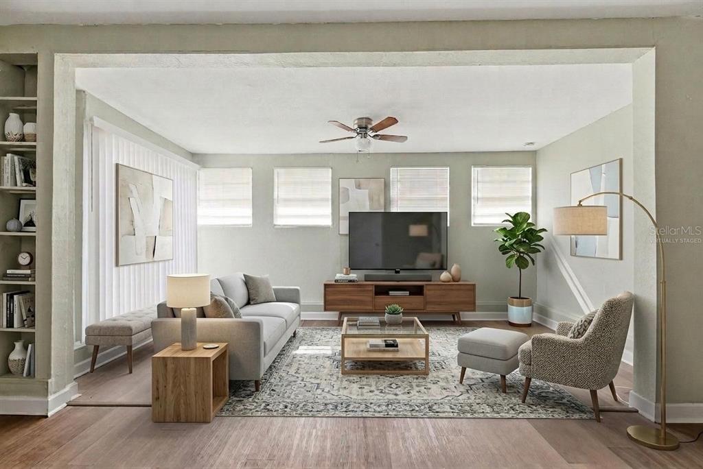 A living room with light walls, wood flooring, a gray sofa, and a television console — 4302 MEADOWBROOK AVENUE, ORLANDO, FL